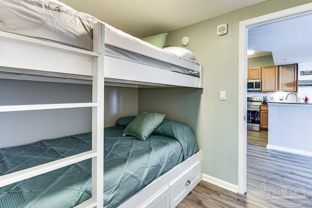 bedroom with sink and hardwood / wood-style floors