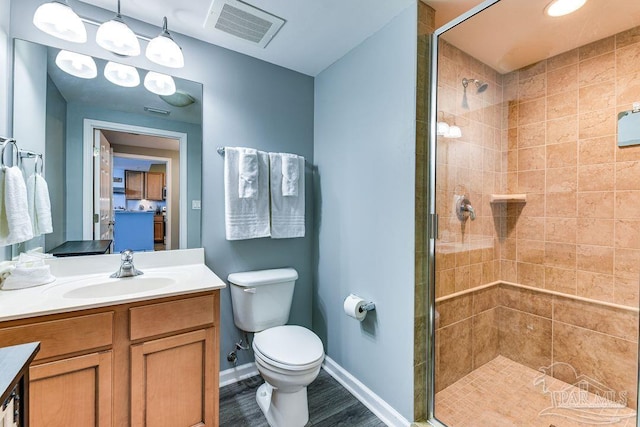 bathroom featuring wood-type flooring, an enclosed shower, vanity, and toilet