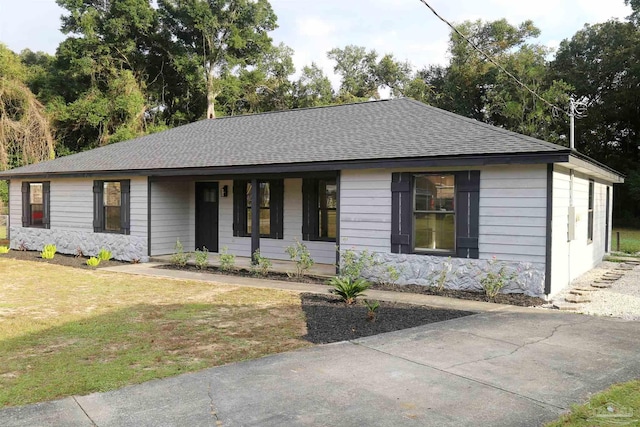 single story home featuring a porch, a shingled roof, and a front yard