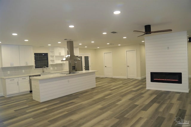 kitchen with stainless steel dishwasher, open floor plan, white cabinetry, island range hood, and black electric cooktop