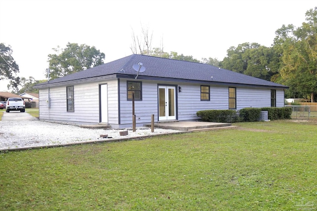 rear view of house with a lawn, a patio, central air condition unit, and french doors