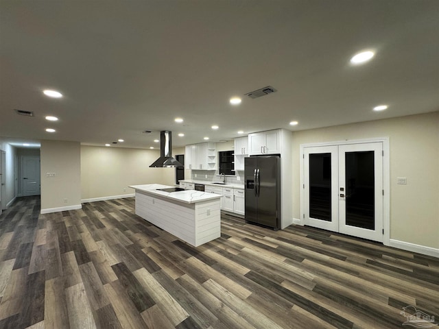 kitchen with visible vents, black appliances, a center island with sink, island exhaust hood, and white cabinetry