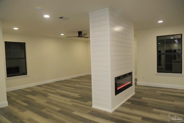 unfurnished living room featuring a glass covered fireplace, wood finished floors, and recessed lighting