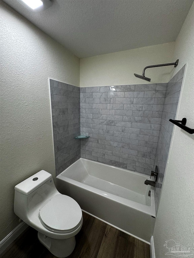 full bath featuring toilet, a textured ceiling, wood finished floors,  shower combination, and a textured wall