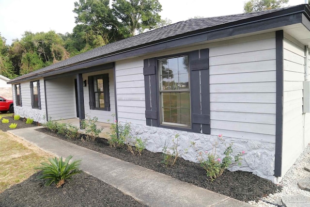 view of side of property featuring roof with shingles