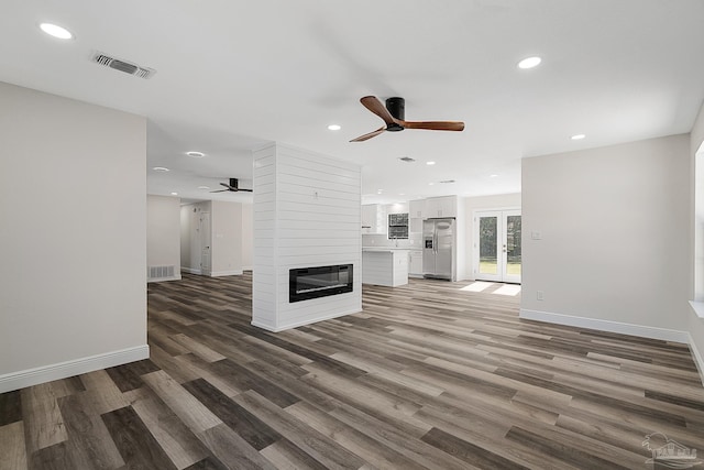 unfurnished living room with visible vents, recessed lighting, a fireplace, french doors, and wood finished floors