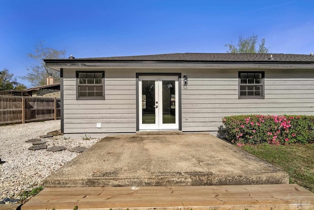 rear view of property featuring french doors and fence