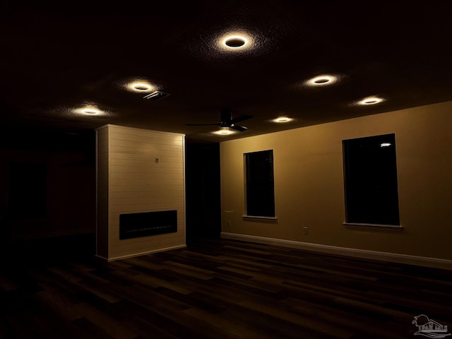 empty room with baseboards, dark wood finished floors, recessed lighting, a fireplace, and ceiling fan