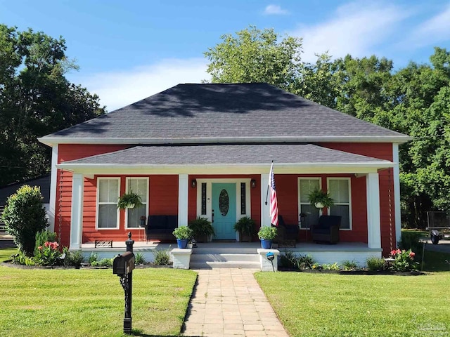 210 Mcrae St, Atmore, AL 36502 - view of front facade with covered porch, a shingled roof, and a front yard