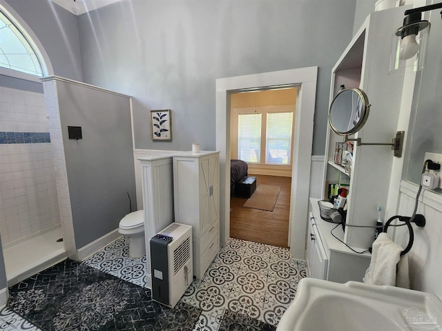 210 Mcrae St, Atmore, AL 36502 - ensuite bathroom with a tile shower, a wainscoted wall, tile patterned floors, and a high ceiling