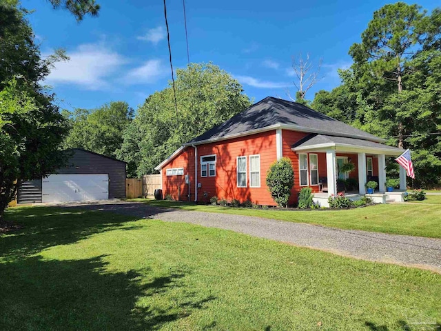 210 Mcrae St, Atmore, AL 36502 - view of front of house featuring an outbuilding, a porch, and a detached garage