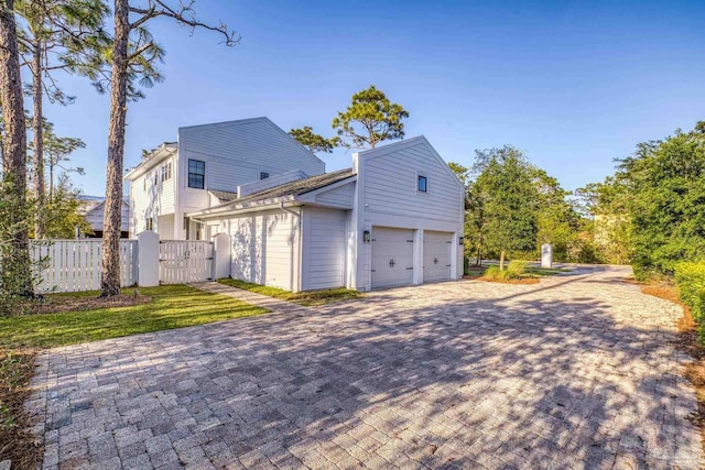 4979 Leeward Dr, Pensacola, FL 32507 - view of side of home featuring fence, a gate, and decorative driveway