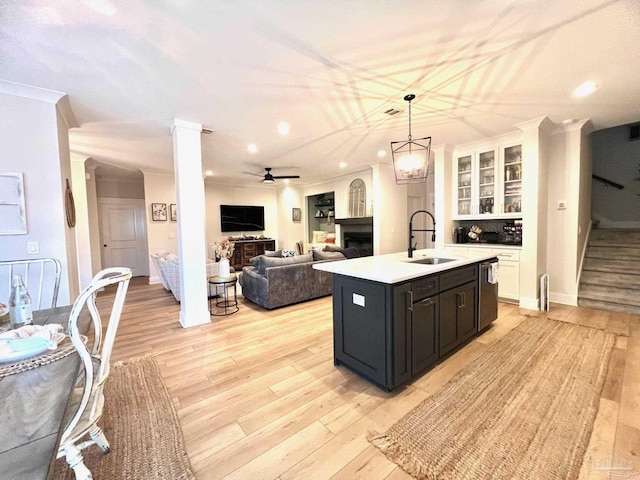 4979 Leeward Dr, Pensacola, FL 32507 - kitchen featuring a sink, light wood-type flooring, light countertops, a fireplace, and an island with sink