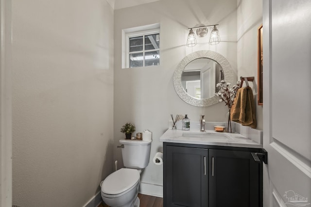 4979 Leeward Dr, Pensacola, FL 32507 - half bathroom featuring baseboards, wood finished floors, vanity, and toilet