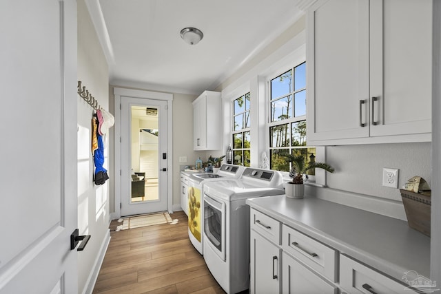 4979 Leeward Dr, Pensacola, FL 32507 - laundry area featuring baseboards, independent washer and dryer, light wood-style floors, and cabinet space