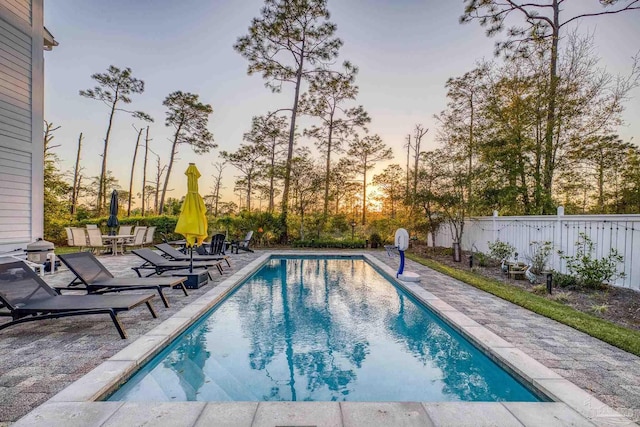 4979 Leeward Dr, Pensacola, FL 32507 - pool at dusk featuring fence, a fenced in pool, and a patio