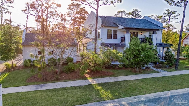 4979 Leeward Dr, Pensacola, FL 32507 - view of front of property featuring a front lawn, roof with shingles, and a balcony