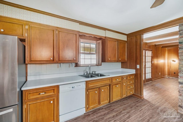 kitchen with dark wood finished floors, white dishwasher, freestanding refrigerator, a sink, and light countertops