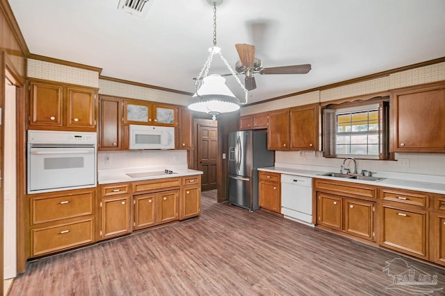 kitchen with visible vents, brown cabinets, white appliances, and wallpapered walls