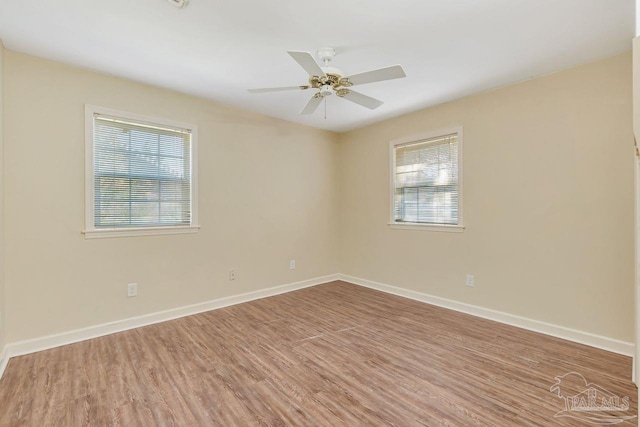 empty room with wood finished floors, baseboards, and ceiling fan