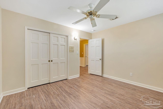 unfurnished bedroom featuring light wood-type flooring, visible vents, a closet, baseboards, and ceiling fan