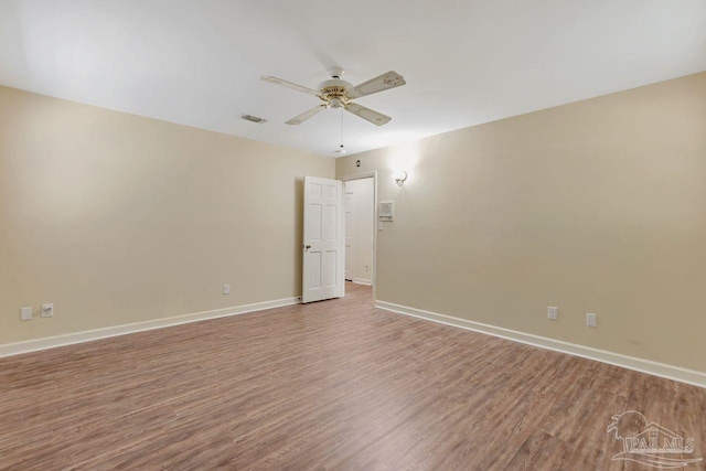 unfurnished room featuring visible vents, baseboards, ceiling fan, and wood finished floors