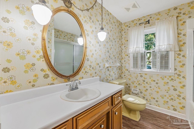 bathroom featuring visible vents, toilet, wallpapered walls, and a shower with shower door