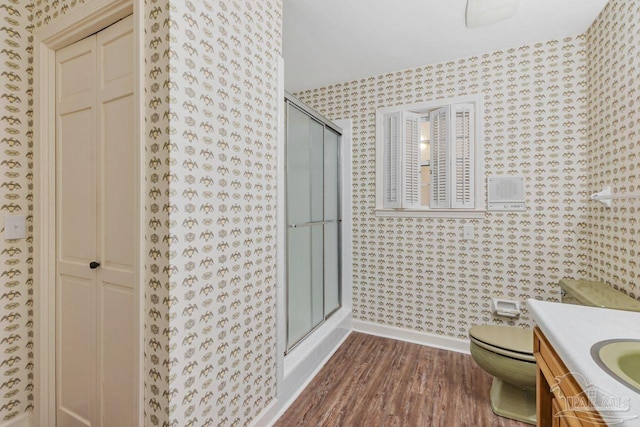 full bath with vanity, wood finished floors, baseboards, a shower stall, and toilet