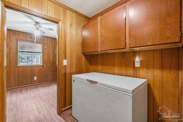 laundry area featuring wood walls, baseboards, light wood-type flooring, and ceiling fan