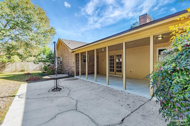 view of patio with french doors and fence