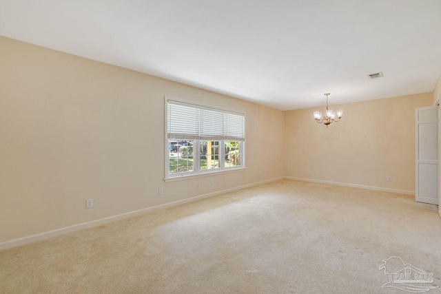 unfurnished room featuring visible vents, light carpet, baseboards, and a chandelier