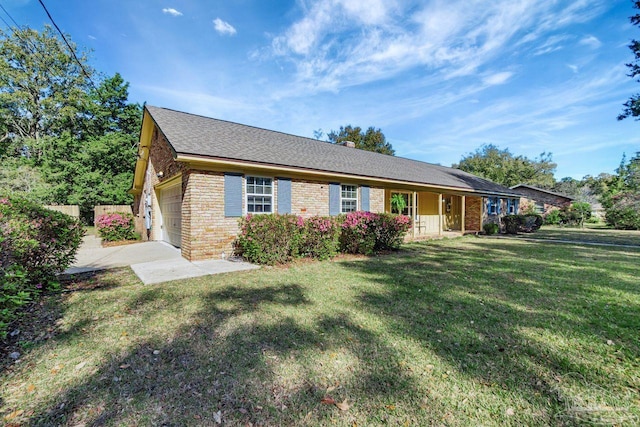 ranch-style house with brick siding, fence, concrete driveway, a front yard, and a garage