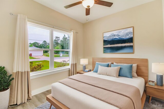 bedroom featuring wood finished floors, baseboards, and ceiling fan