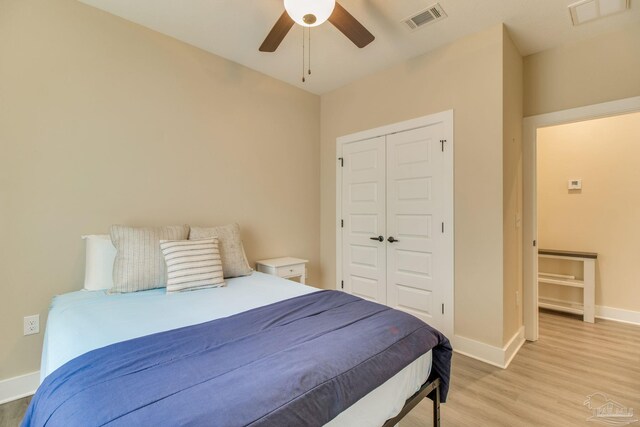 bedroom featuring light wood-style floors, baseboards, a closet, and a ceiling fan