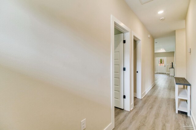 hall with light wood-type flooring, baseboards, and recessed lighting