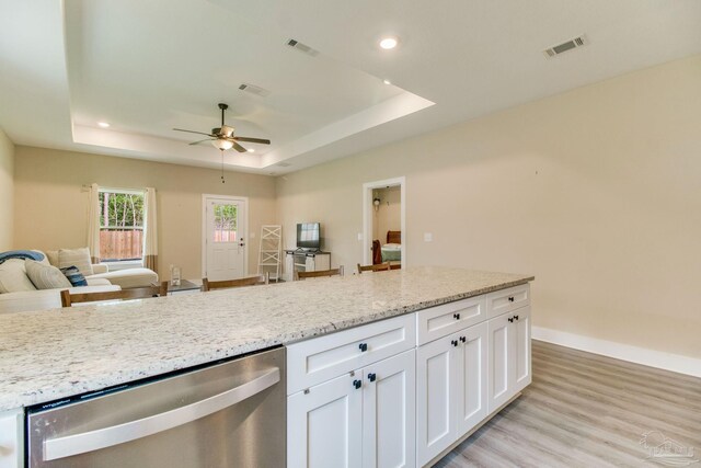 kitchen featuring stainless steel dishwasher, a raised ceiling, white cabinetry, a ceiling fan, and recessed lighting