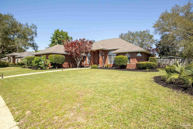 1126 Mary Kate Dr, Gulf Breeze, FL 32563 - ranch-style home with brick siding, roof with shingles, a front lawn, and fence