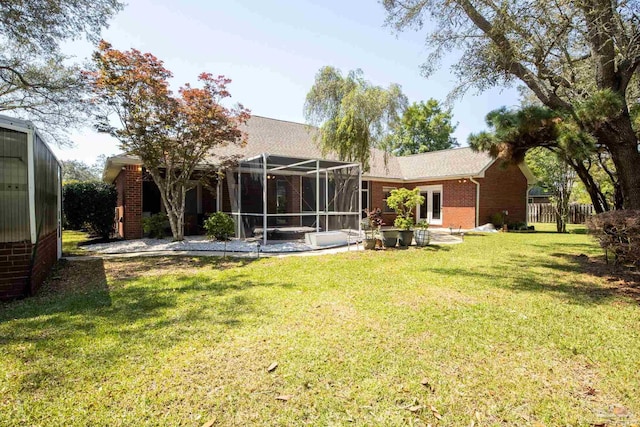 1126 Mary Kate Dr, Gulf Breeze, FL 32563 - back of property featuring a patio, glass enclosure, a yard, and brick siding