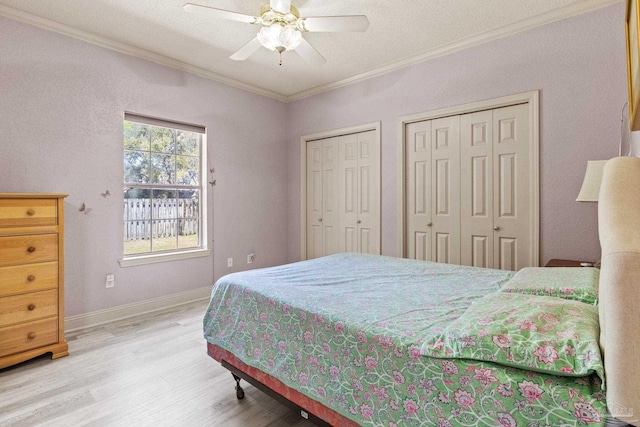 1126 Mary Kate Dr, Gulf Breeze, FL 32563 - bedroom featuring wood finished floors, a ceiling fan, ornamental molding, baseboards, and two closets