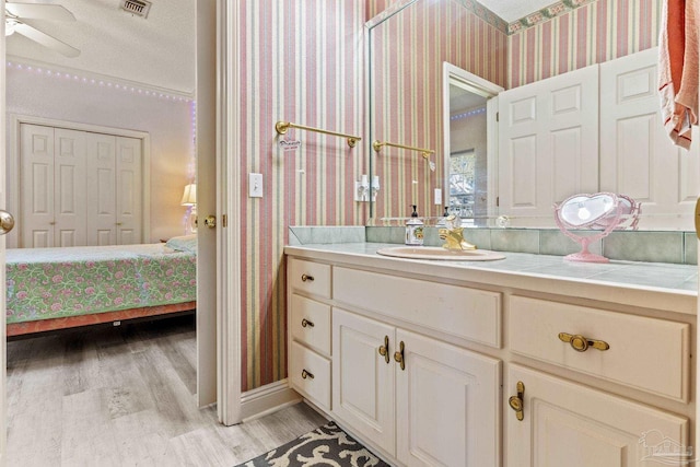 1126 Mary Kate Dr, Gulf Breeze, FL 32563 - bathroom with wallpapered walls, wood finished floors, visible vents, vanity, and ensuite bath