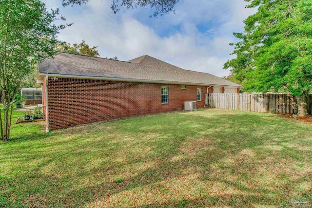 1126 Mary Kate Dr, Gulf Breeze, FL 32563 - back of house with central AC, brick siding, fence, and a lawn