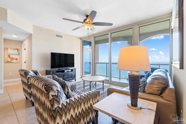 tiled living room with a textured ceiling and ceiling fan