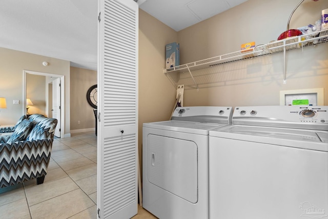 laundry area with separate washer and dryer and light tile patterned floors