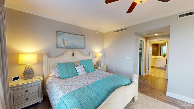 bedroom with crown molding, ensuite bath, ceiling fan, and hardwood / wood-style flooring