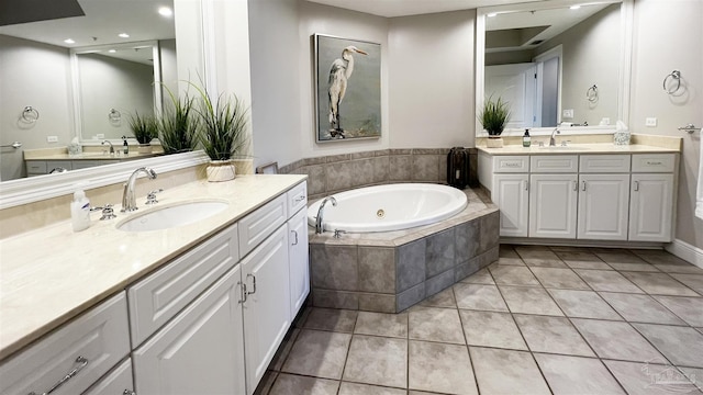 bathroom with tiled tub, vanity, and tile patterned floors