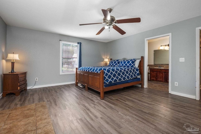 bedroom with connected bathroom, ceiling fan, dark wood-type flooring, and a textured ceiling