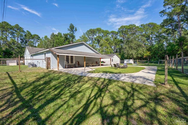 back of house with a lawn and a patio