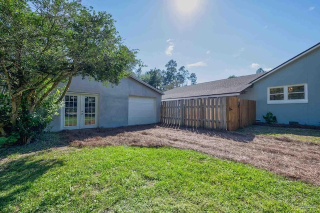 view of yard featuring french doors and a garage