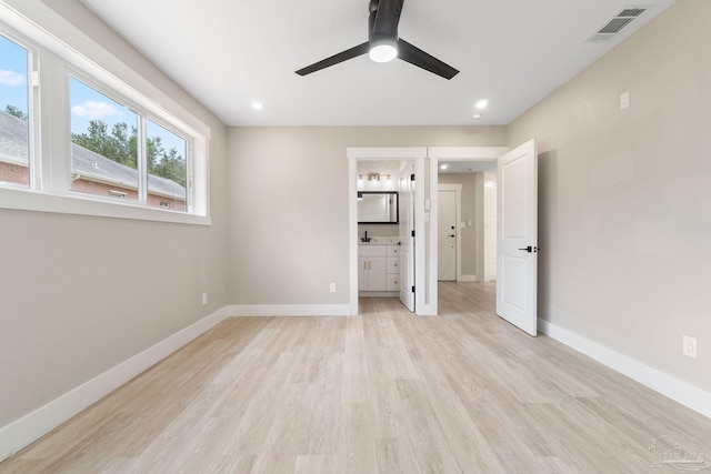 unfurnished bedroom with light wood-type flooring, connected bathroom, and ceiling fan