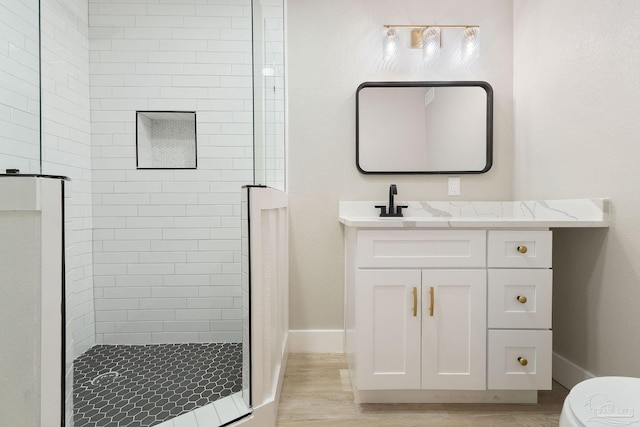 bathroom with hardwood / wood-style floors, vanity, toilet, and walk in shower